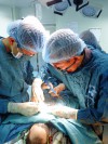 Bác sỹ Nguyễn Văn Bình (bên phải) phẫu thuật tái lập lưu thông tiêu hóa sau cắt ruột non hoại tử ở bé trai 5 ngày tuổi (Ảnh: Bội Nhiên)